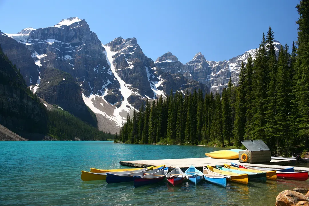 Rental canoes tied up at a dock on a mountain lake