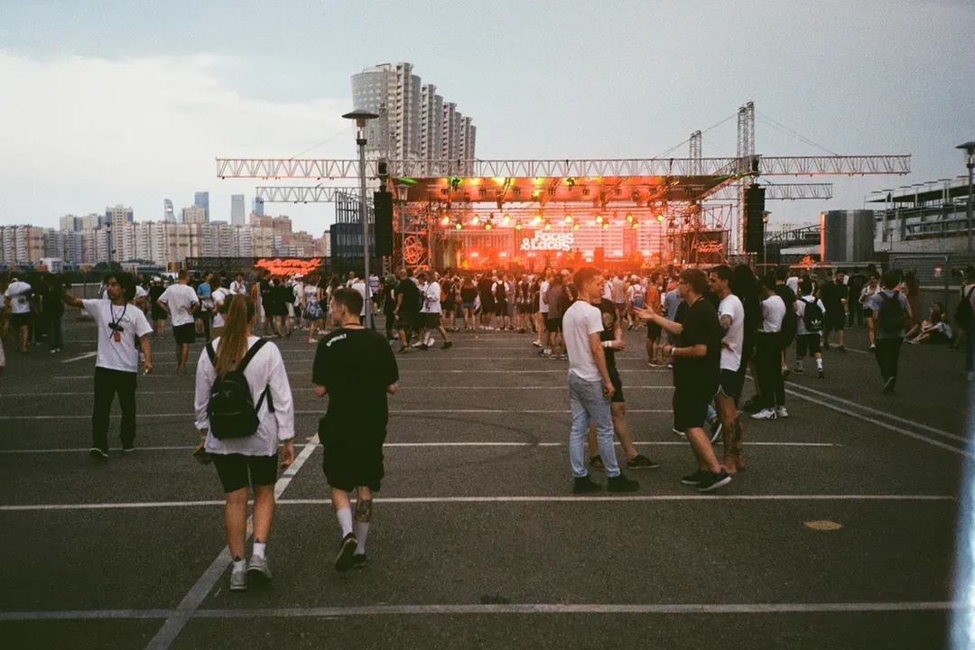 Crowd gathered in front of an outdoor event stage at dusk